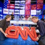Two of the CNN employees carrying CNN logo on a set. Courtesy CNN Live